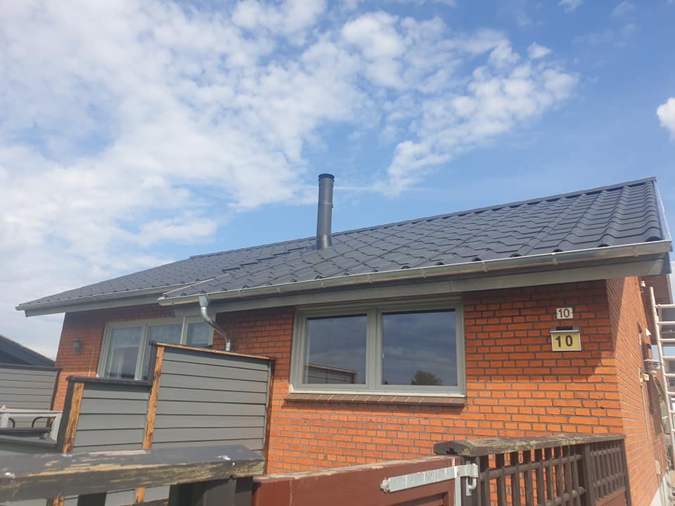 Færdigt nyt tag på murstenshus med moderne tagsten og zinkinddækninger.