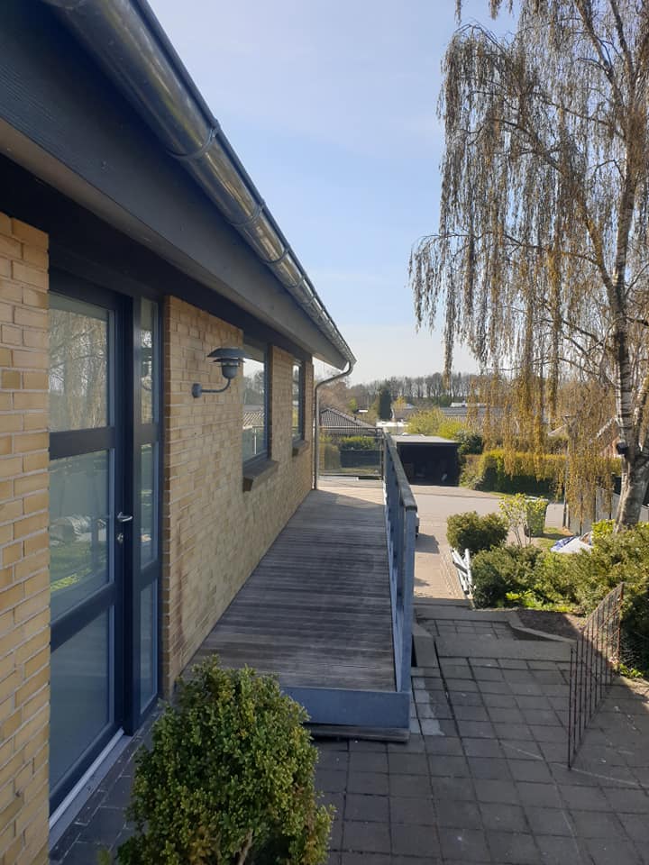 Gangareal og terrasse ved bolig med nye døre og facadeelementer.