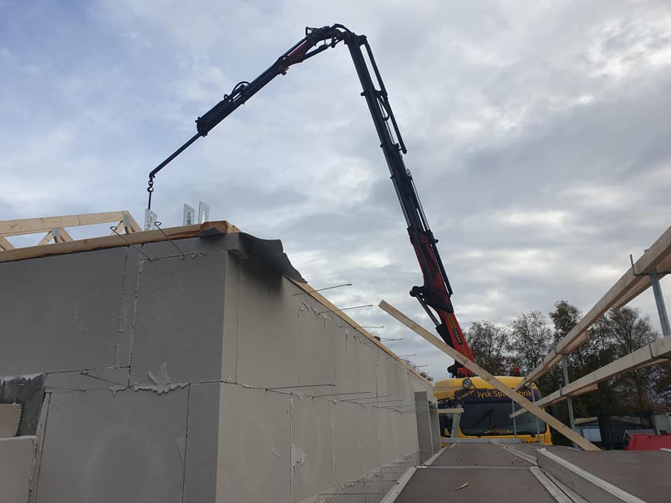 Tømrer arbejder med tagkonstruktion i træ under opbygning